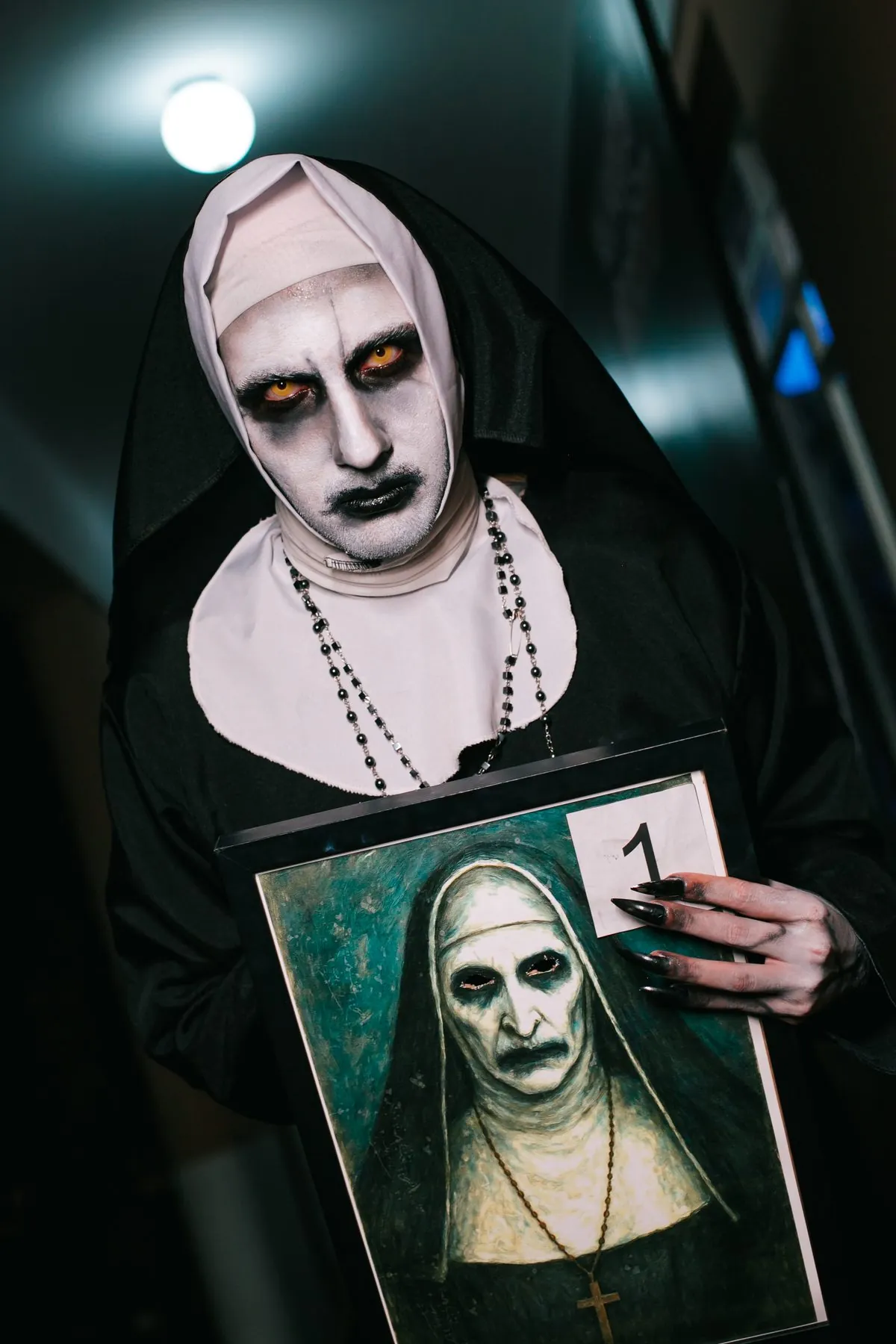 Cosplay da freira Valak segurando o próprio retrato