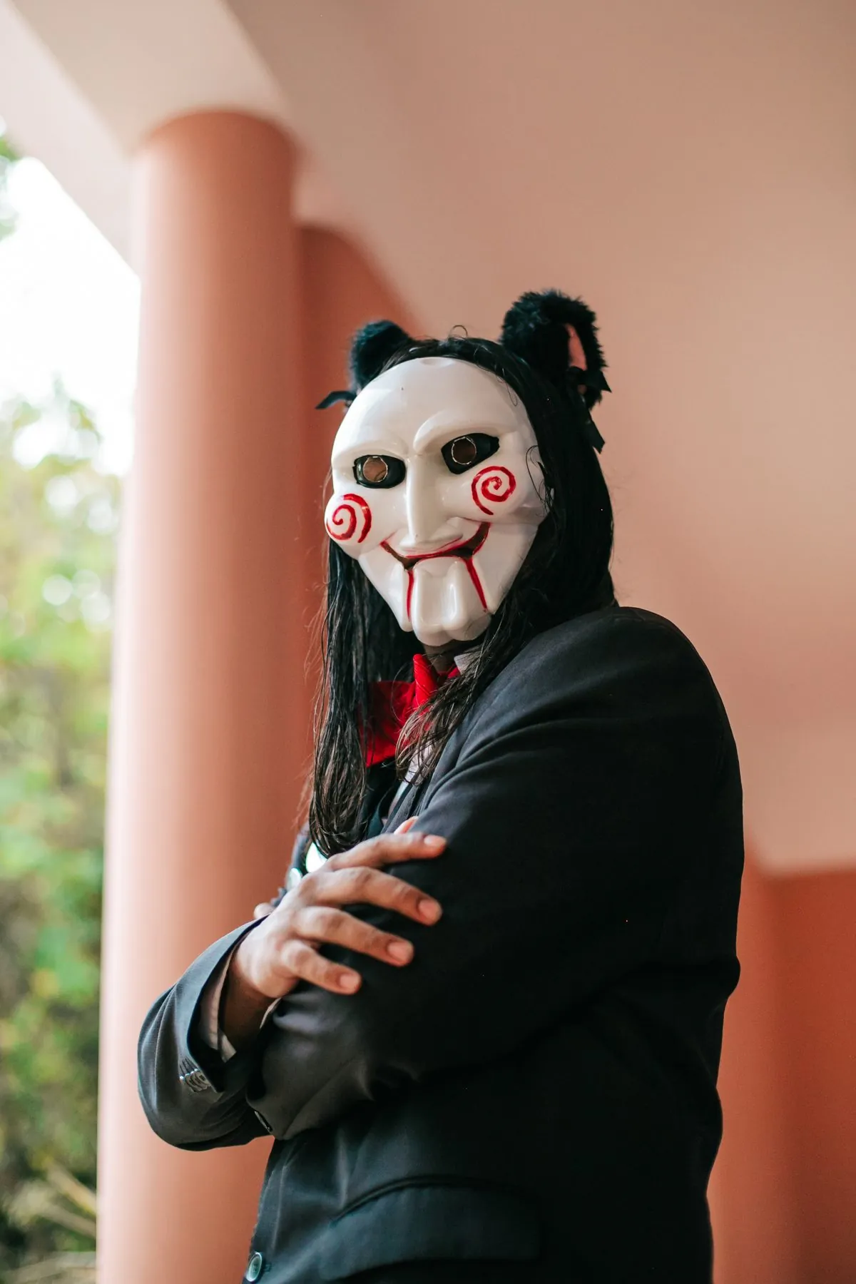 Cosplay do fantoche de Jogos Mortais de braços cruzados